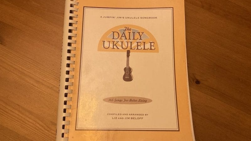 Daily Ukulele songbook on wood background